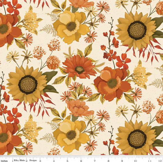 A repeating floral pattern on a cream background with large yellow sunflowers, orange and peach flowers, green leaves, and small red-orange blossoms. A white ruler runs along the bottom edge showing the scale of the print.