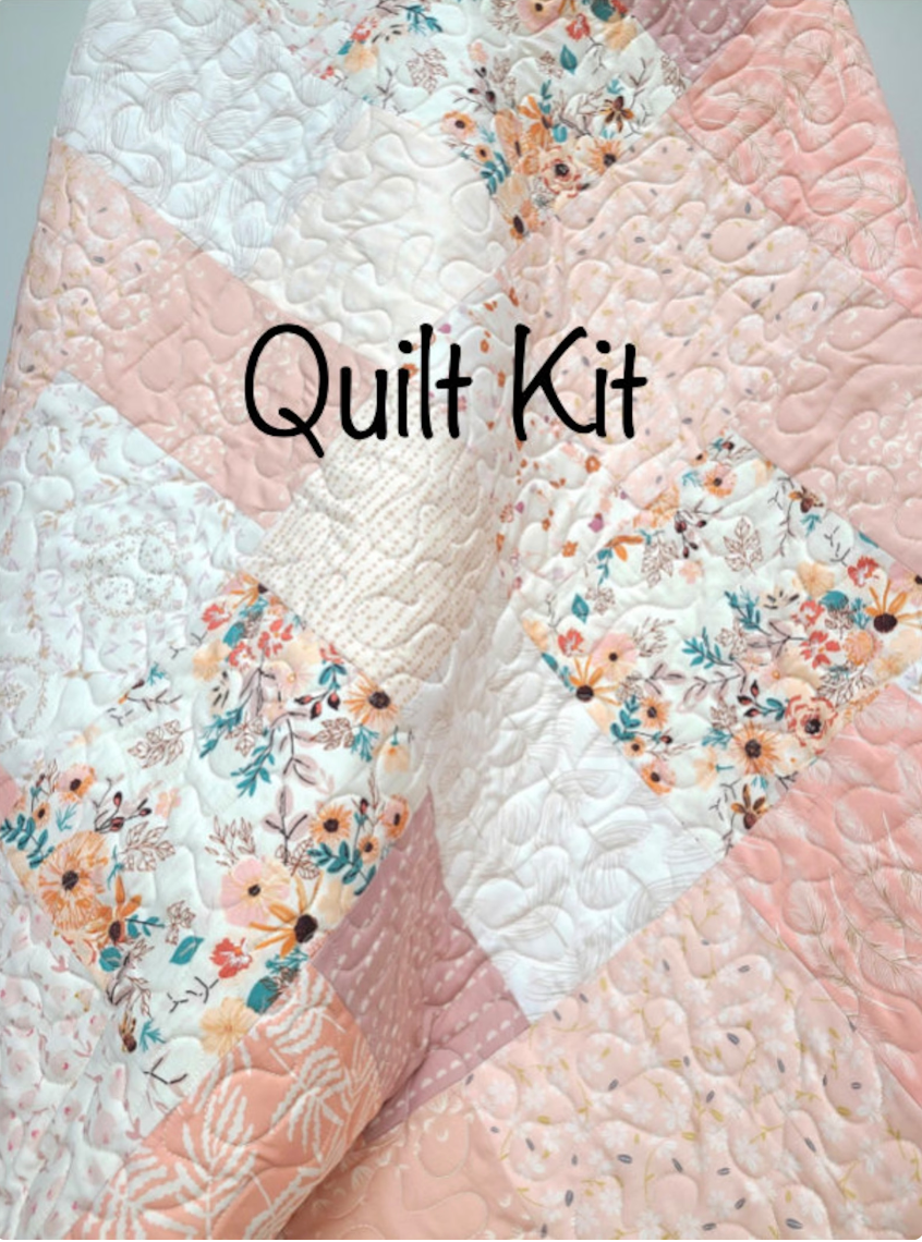 DIY pink farmhouse crib quilt kit showing a modern patchwork pattern with soft blush pink, cream, and light coral fabrics featuring delicate floral and geometric prints with an elegant swirled quilted texture